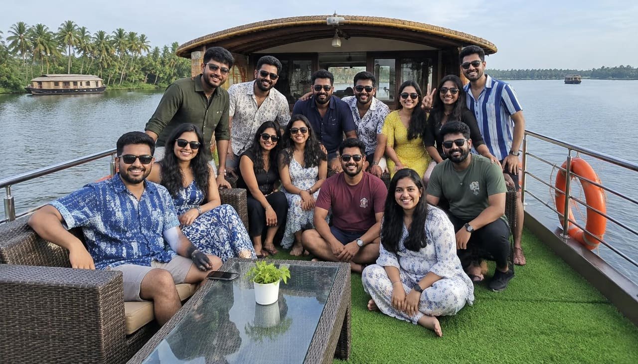Large group of friends smiling on a houseboat deck in Alleppey