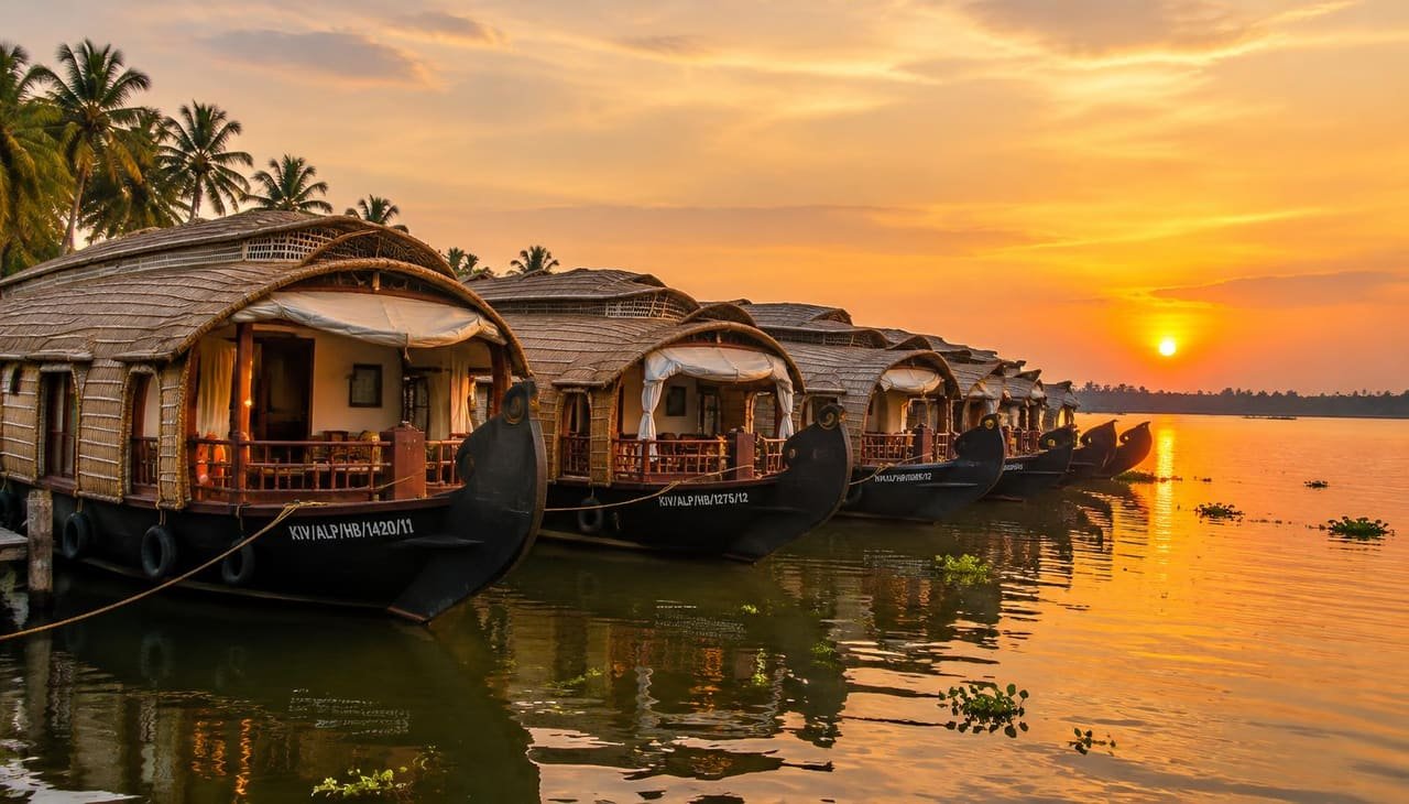 Traditional Kerala houseboats moored on Punnamada lake at golden hour
