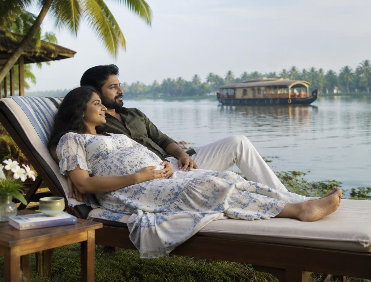 Expecting couple relaxing on a lakeside lounger at a Kumarakom resort