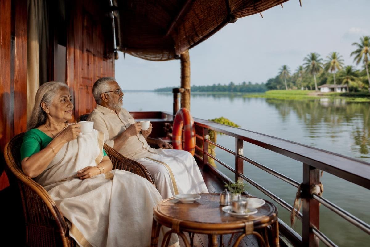 Senior couple enjoying tea on a houseboat deck on the Kerala backwaters