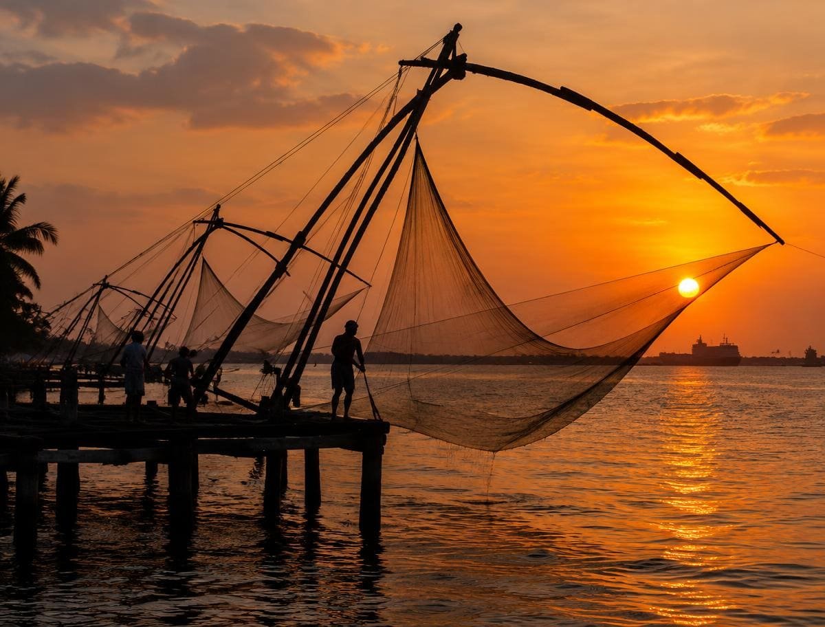 Chinese fishing nets of Fort Kochi silhouetted against an orange sunset